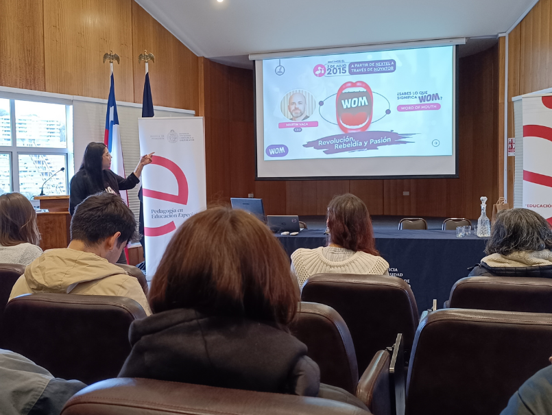 Profesional de WOM exponiendo ante estudiantes y académicas de la PUCV.