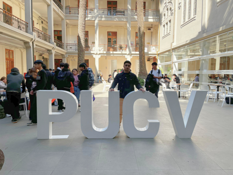 Maximiliano se ubica en medio de letras de la PUCV, su Casa de Estudios. 